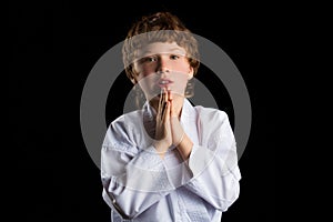 Karate boy in white kimono isolated on black