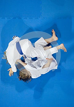 Karate do kids fight against blue tatami background. Top View. S