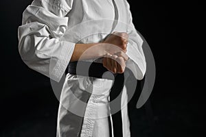 Karate fighter in white kimono having black belt
