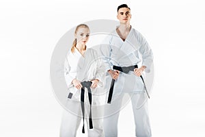 karate fighters holding black belts and looking at camera