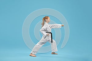 Karate girl with black belt practicing martial arts.