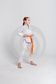 Karate girl in kimono in stand at studio background