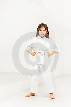 Karate girl standing with hands on hips in gym