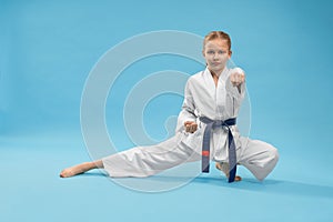 Karate girl standing in stance and training punching.