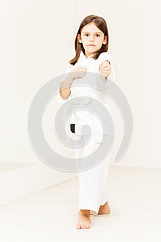 Karate girl wearing kimono standing in stance