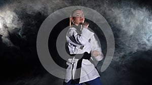 Karate kick girl in kimono practice technical shots. Black