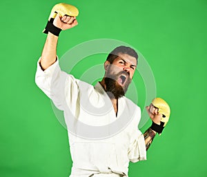 Karate man with angry face in golden boxing gloves.