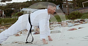 Karate, man and push ups on beach for training in nature with strength for fitness, exercise and workout on sand