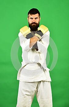 Karate man with serious face in uniform and boxing gloves