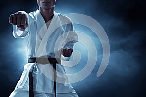 Karate martial arts fighter on dark background photo