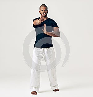 Karate, master and portrait of fight in martial arts training or challenge with hands on white background. Studio