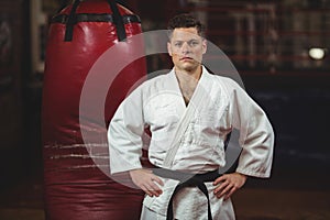 Karate player with hands on hips standing in fitness studio