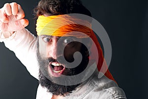 Karate portrait with angry expression posing against grey background