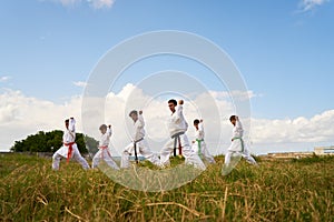 Karate School With Teacher And Boys Warming Up