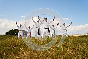 Karate School With Trainers And Young Boys Showing Fighting Tech