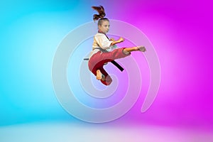 Karate, taekwondo girl with black belt isolated on gradient background in neon light