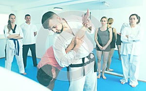 Karate teacher demonstrates techniques of receptions