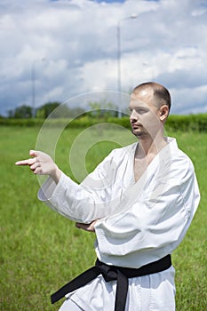 Karate trainer shows tricks.White kimono. Black belt in karate.