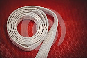 Karate white belt on red background