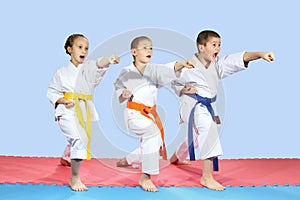 In karategi three athletes are hitting karate kick arm