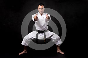 Karateka practicing kata with black background photo