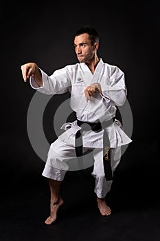 Karateka practicing kata with black background photo