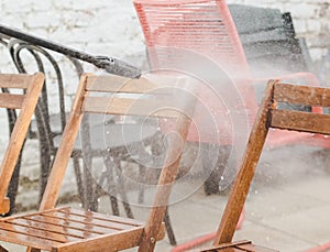 Karcher washing wooden garden chairs in the backyard