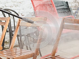 Karcher washing wooden garden chairs in the backyard photo