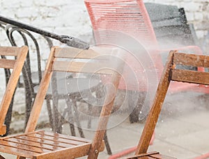 Karcher washing wooden garden chairs in the backyard photo