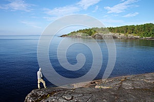 Karelia, Russia - Jule, 2021: A fisherman catches fish on the shores of Lake Ladoga