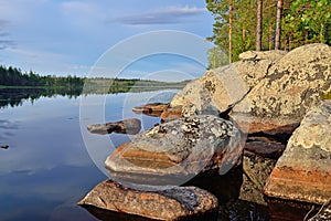 Karelian landscape - rocks, pine trees and water. Lake Pongoma, Northern Karelia, Russia