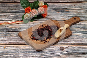 Karkade tea. Hibiscus tea leaves in wooden scoop isolated on wooden background. File contains clipping path. Top view