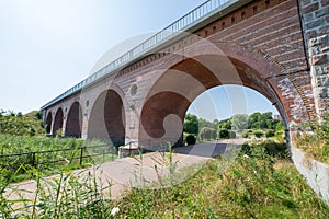 Karlino, Zachodniopomorskie / Poland - August, 7, 2020: Old brick railway bridge over a small river. Brick building in Central photo