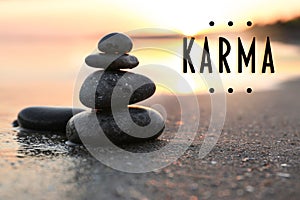 Karma concept. Stones on sand near sea at sunset