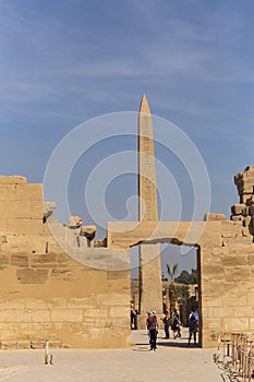 Karnak Temple, complex of Amun-Re. Embossed hieroglyphics on columns and walls. Tourists visiting the sights.