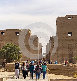 Karnak Temple, complex of Amun-Re. Embossed hieroglyphics on columns and walls. Tourists visiting the sights