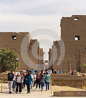 Karnak Temple, complex of Amun-Re. Embossed hieroglyphics on columns and walls. Tourists visiting the sights