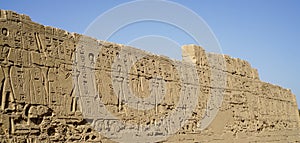 Karnak temple heiroglyphic pharaoh and god carving on stone wall