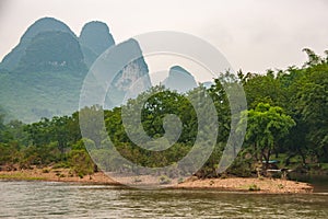 Karst mountain range flat brown rock shorline along Li River in Guilin, China