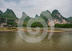 Karst mountains and cliffs behind water along Li River in Guilin, China