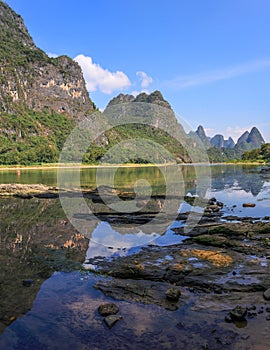 Karst mountains landscape on the Li River with reflection and stony foreground Guilin, China