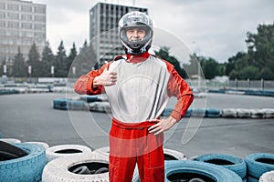 Kart driver in helmet, karting track on background