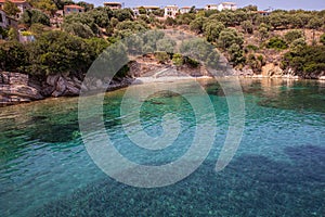 Kastos island summer picturesque nature with turquoise crystal clear water, rocky beach, green trees, houses - Ionian