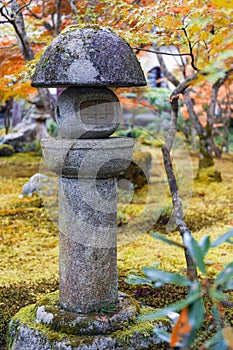 Kasuga doro or stone lantern in Japanese maple garden during autumn at Enkoji temple, Kyoto, Japan