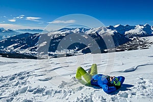 Katschberg - A man lying on the powder snow with his skies aned enjoying the winter day in Austrian Alps