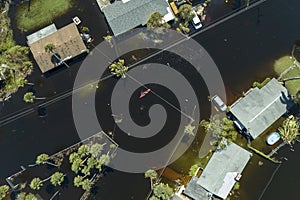 Kayak boat floating on flooded street surrounded by hurricane Ian rainfall flood waters homes in Florida residential