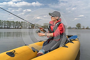 Kayak fishing at lake. Fisherwoman on inflatable boat with fishing tackle