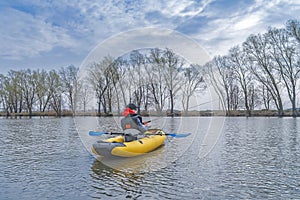 Kayak fishing at lake. Fisherwoman on inflatable boat with fishing tackle