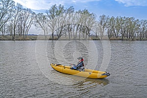 Kayak fishing at lake. Fisherwoman on inflatable boat with fishing tackle