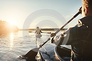 Kayak, lake and people rowing a boat on the water during summer for recreation or leisure at sunset. Nature, view and